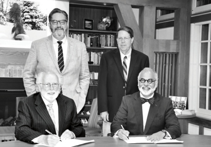 St. Michael’s President David Sylvester, Regis President Thomas Worcester, SJ, St. Michael’s Collegium Chair Paul Harris, and Peter Warrian, Chair of the Governing Council at Regis, sign the Memorandum of Agreement.